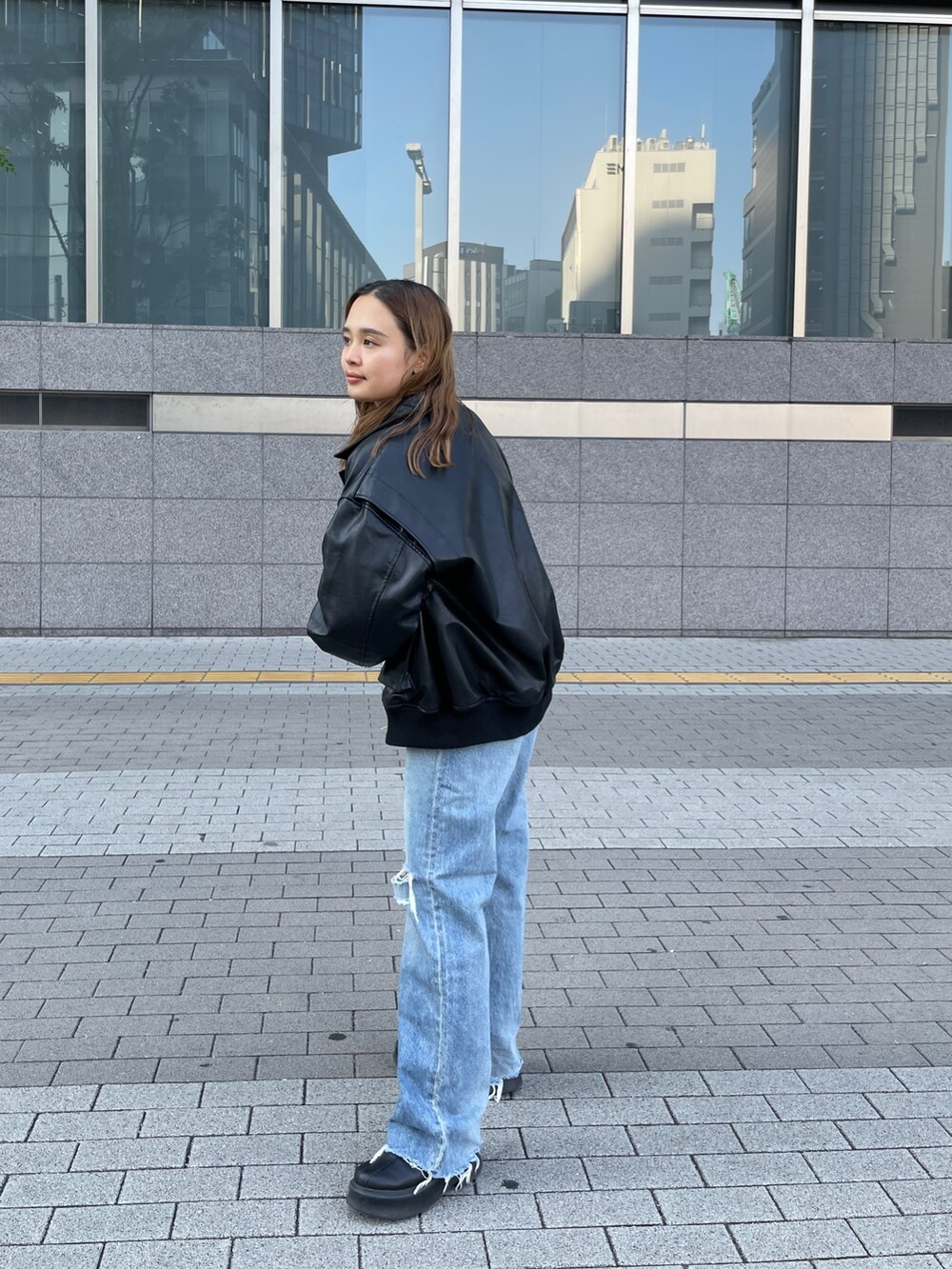 ピンク系のニット/セーター、ブルー系のデニムパンツを着用したレディースの秋コーディネートの3枚目の写真