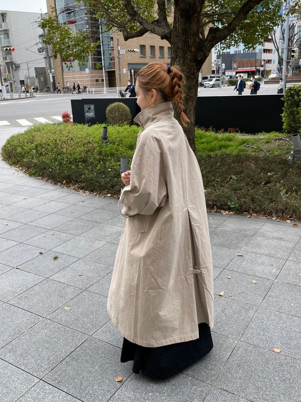 グリーン系のワンピース、ブルー系のトートバッグ、ベージュ系のステンカラーコートを着用したレディースの春コーディネートの3枚目の写真