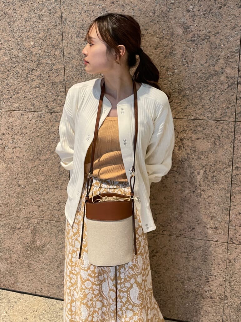 イエロー系のスカート、ホワイト系のパンプス、ホワイト系のカーディガン/ボレロを着用したレディースの冬コーディネートの5枚目の写真