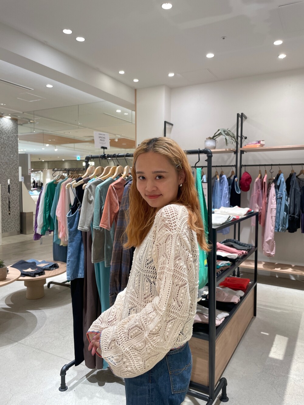 ホワイト系のニット/セーター、ブルー系のデニムパンツを着用したレディースの秋コーディネートの5枚目の写真