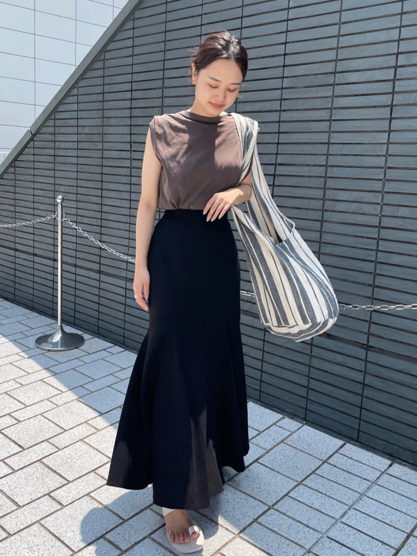 ホワイト系のサンダル、ブラウン系のタンクトップ、ブラック系のスカートを着用したレディースの夏コーディネートの2枚目の写真