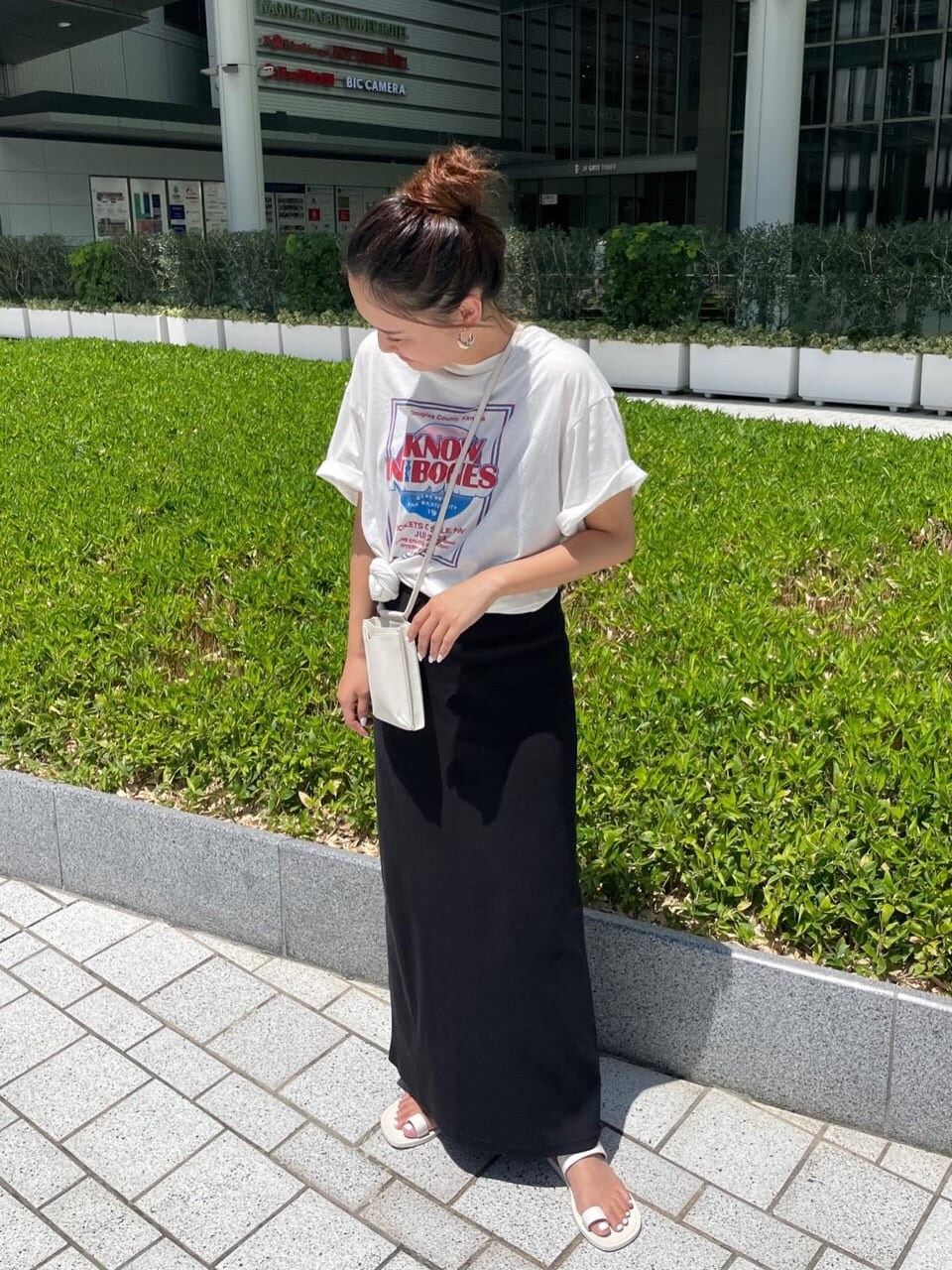 ホワイト系のTシャツ/カットソー、ホワイト系のサンダル、ブラック系のワンピースを着用したレディースの夏コーディネートの3枚目の写真