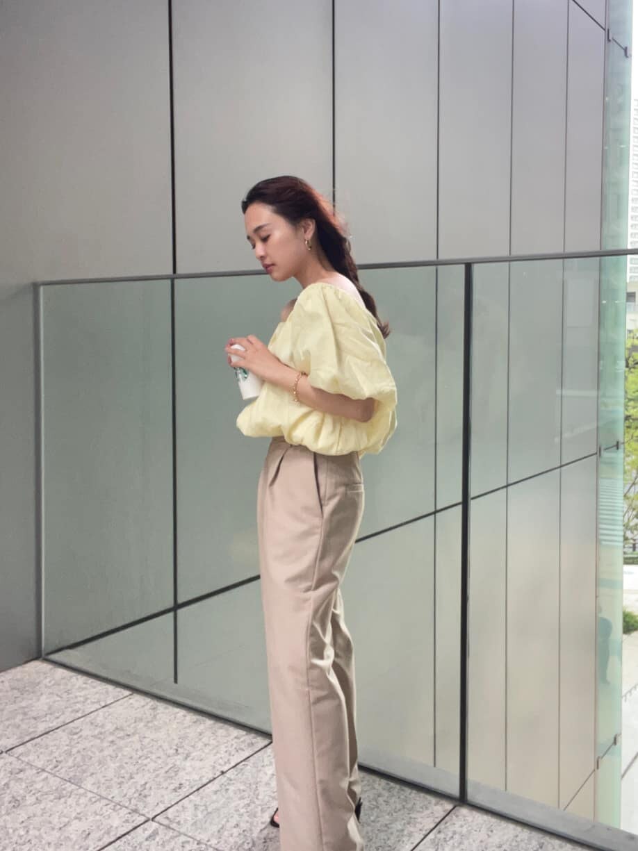 ベージュ系のその他パンツ、イエロー系のシャツ/ブラウス、ゴールド系のブレスレットを着用したレディースの春コーディネートの2枚目の写真