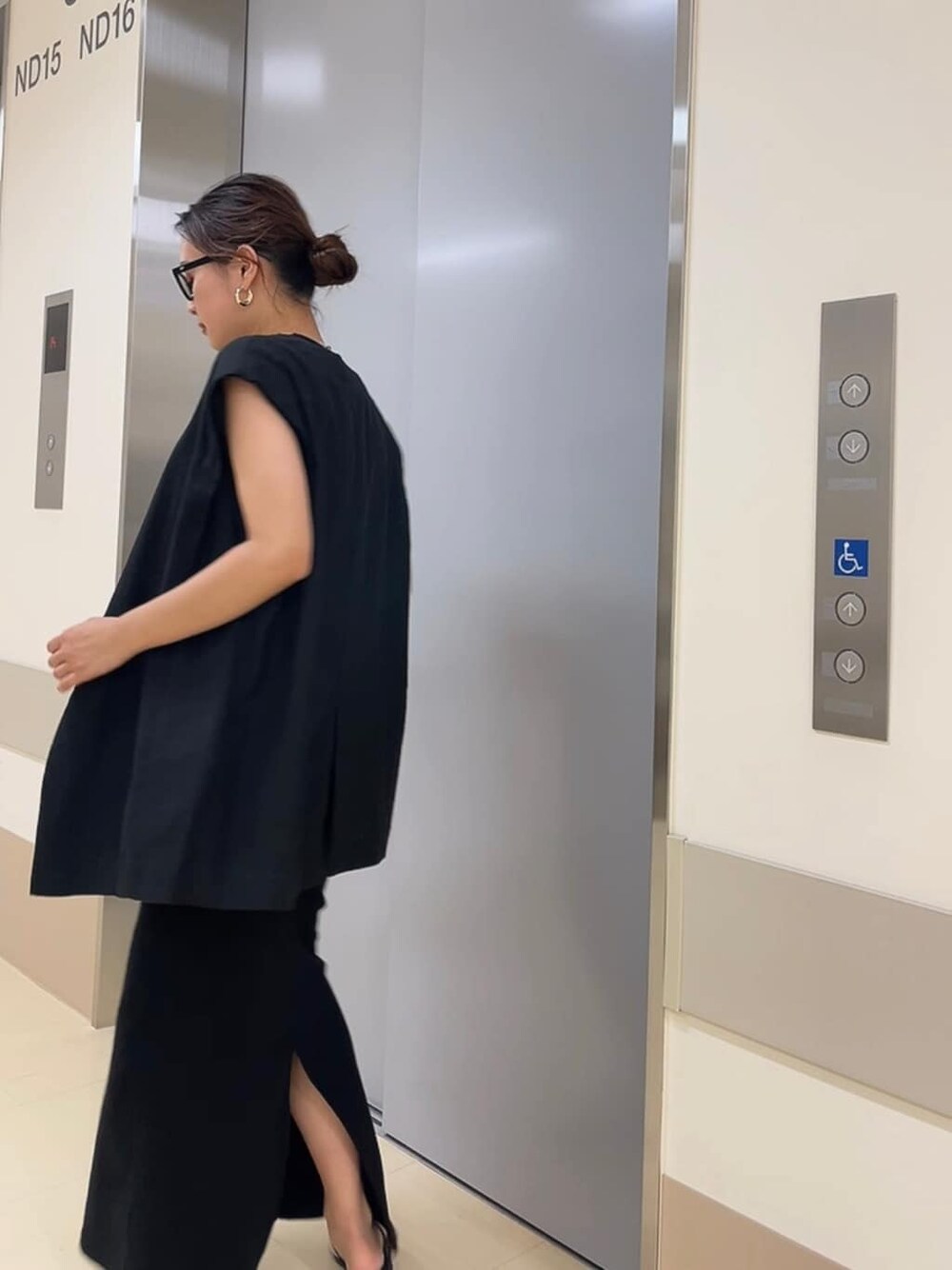 ブラック系のワンピース、ブラック系のベスト、ブラック系のサンダルを着用したレディースの夏コーディネートの3枚目の写真