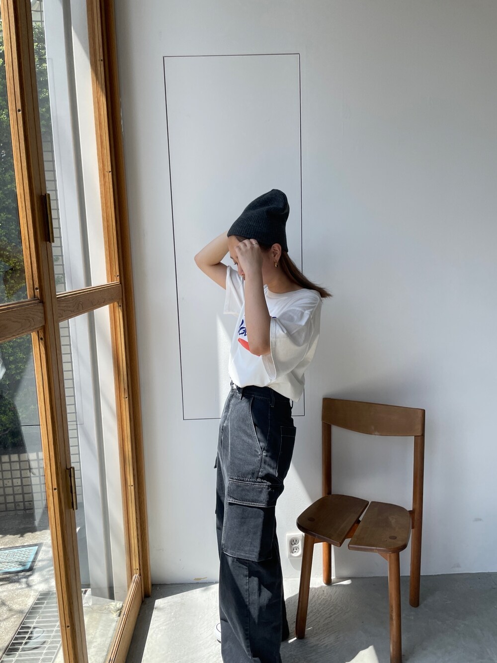 ホワイト系のTシャツ/カットソー、ブラック系のデニムパンツ、ブラック系のニットキャップ/ビーニーを着用したレディースの夏コーディネートの6枚目の写真