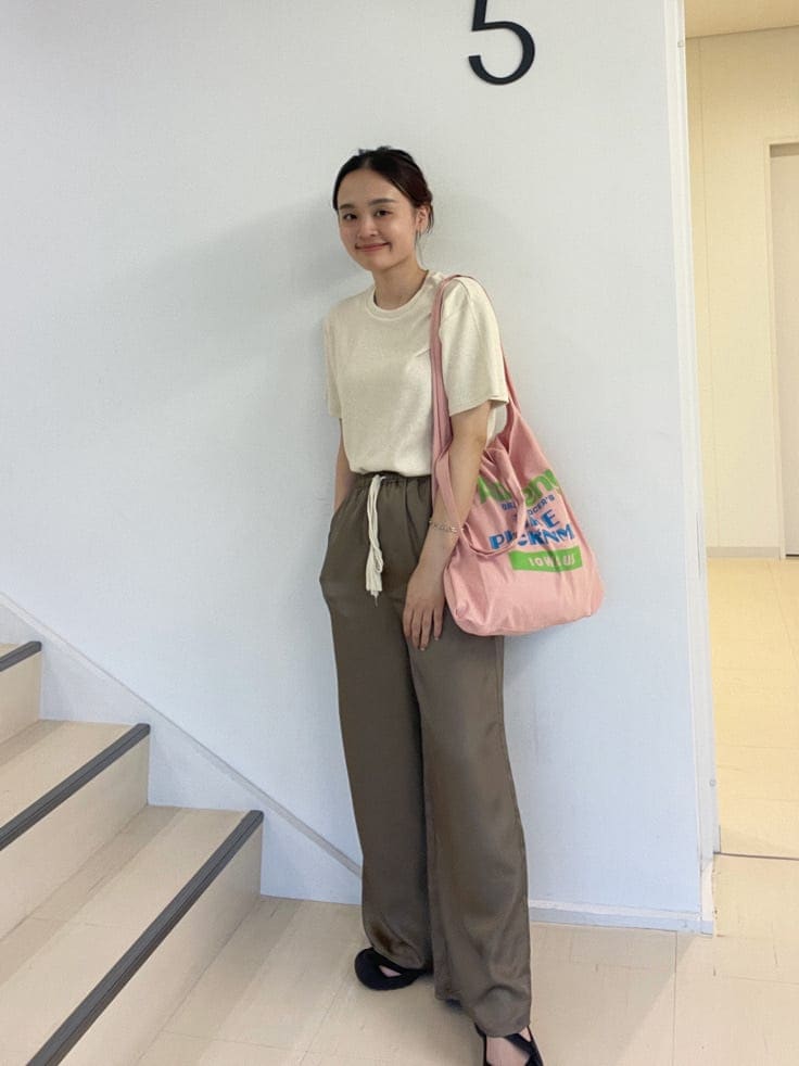 ピンク系のエコバッグ/サブバッグ、ブラウン系のその他パンツ、ホワイト系のTシャツ/カットソーを着用したレディースの夏コーディネートの7枚目の写真