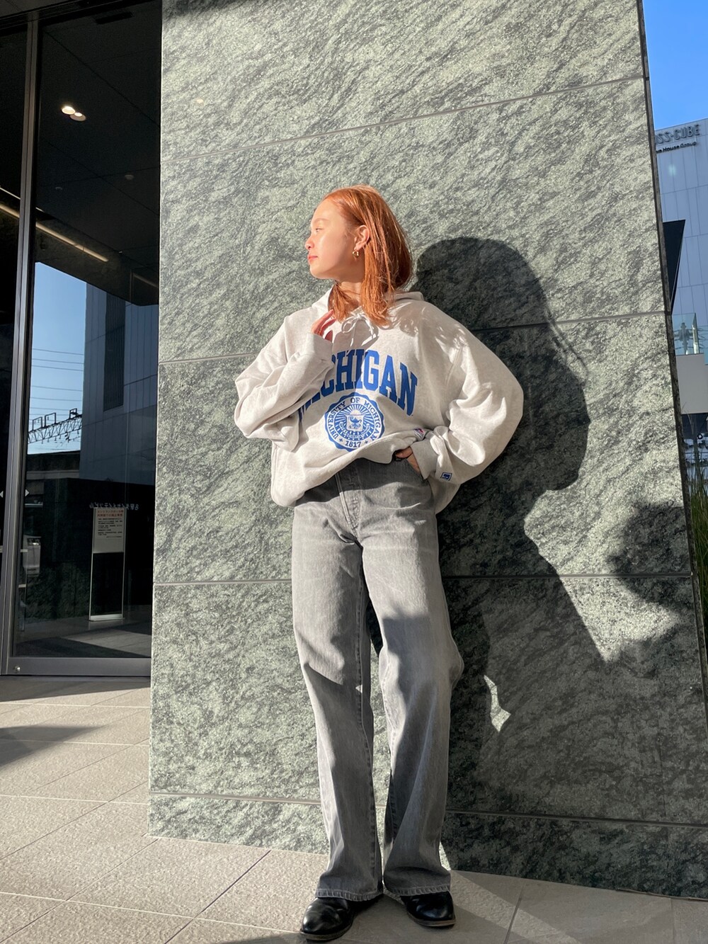 ブラック系のデニムパンツ、グレー系のパーカーを着用したレディースの冬コーディネートの6枚目の写真