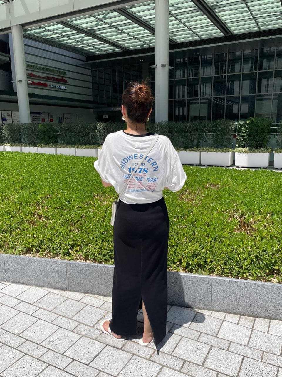 ホワイト系のTシャツ/カットソー、ホワイト系のサンダル、ブラック系のワンピースを着用したレディースの夏コーディネートの5枚目の写真