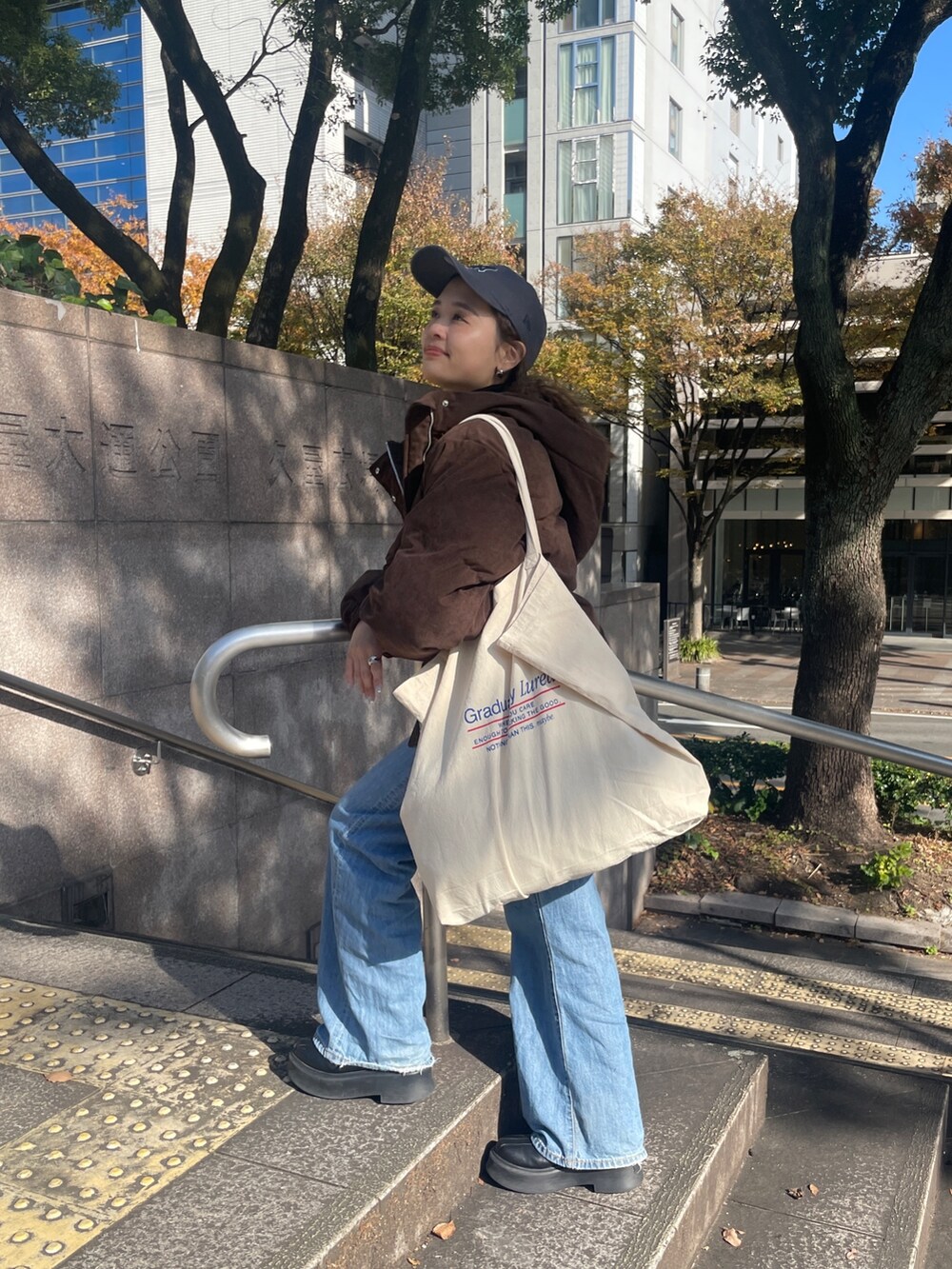 ブルー系のデニムパンツ、ブラウン系のブルゾン、ブラック系のニット/セーターを着用したレディースの冬コーディネートの3枚目の写真