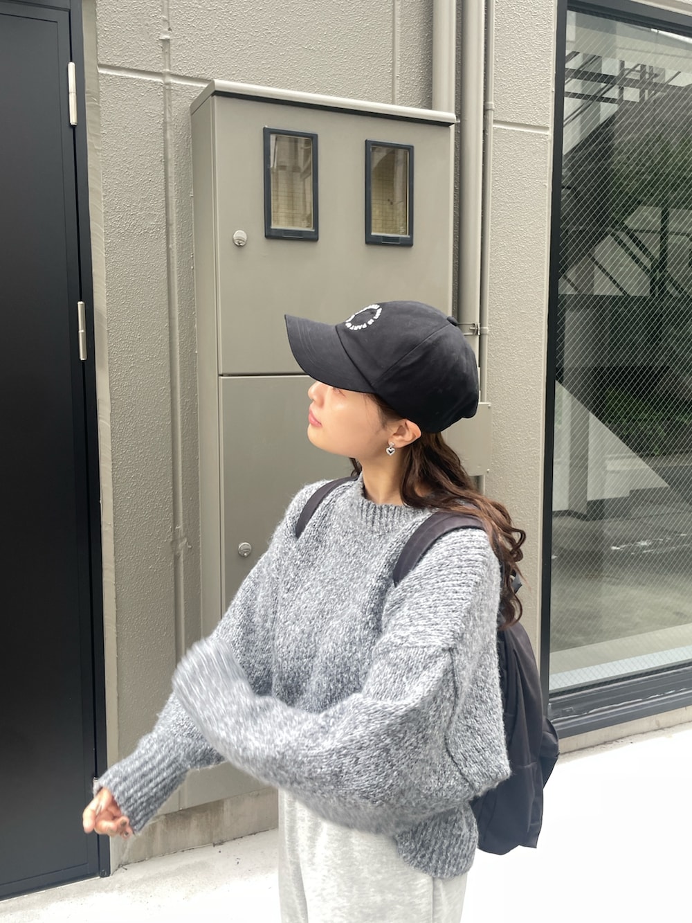 グレー系のスウェットパンツ、グレー系のニット/セーター、ブラック系のキャップを着用したレディースの秋コーディネートの3枚目の写真