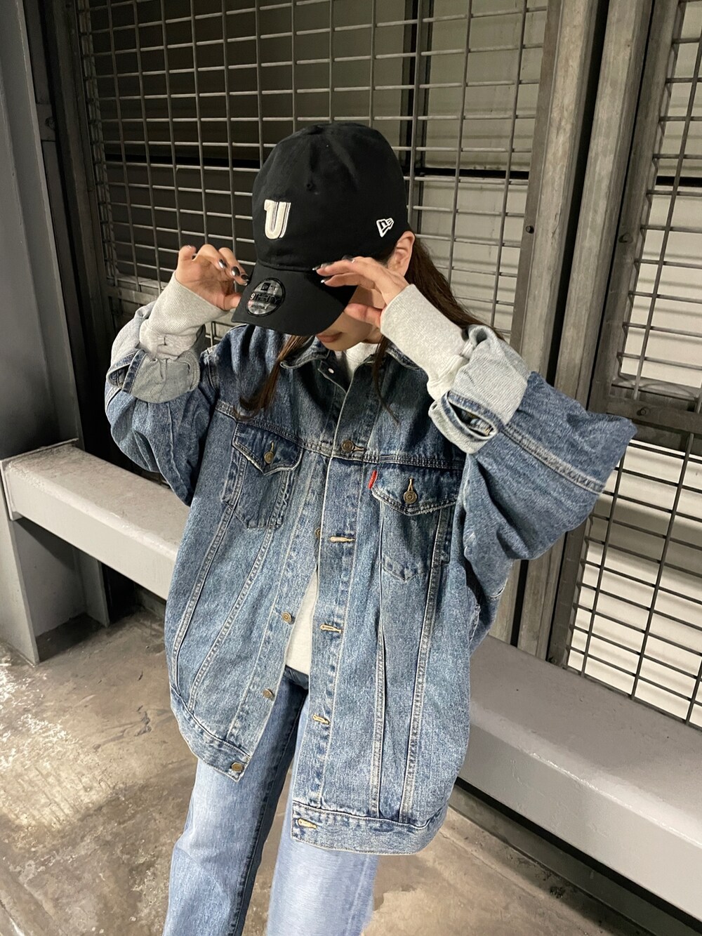 ブルー系のデニムジャケット、ブルー系のデニムパンツ、グレー系のスウェットを着用したレディースの冬コーディネートの3枚目の写真