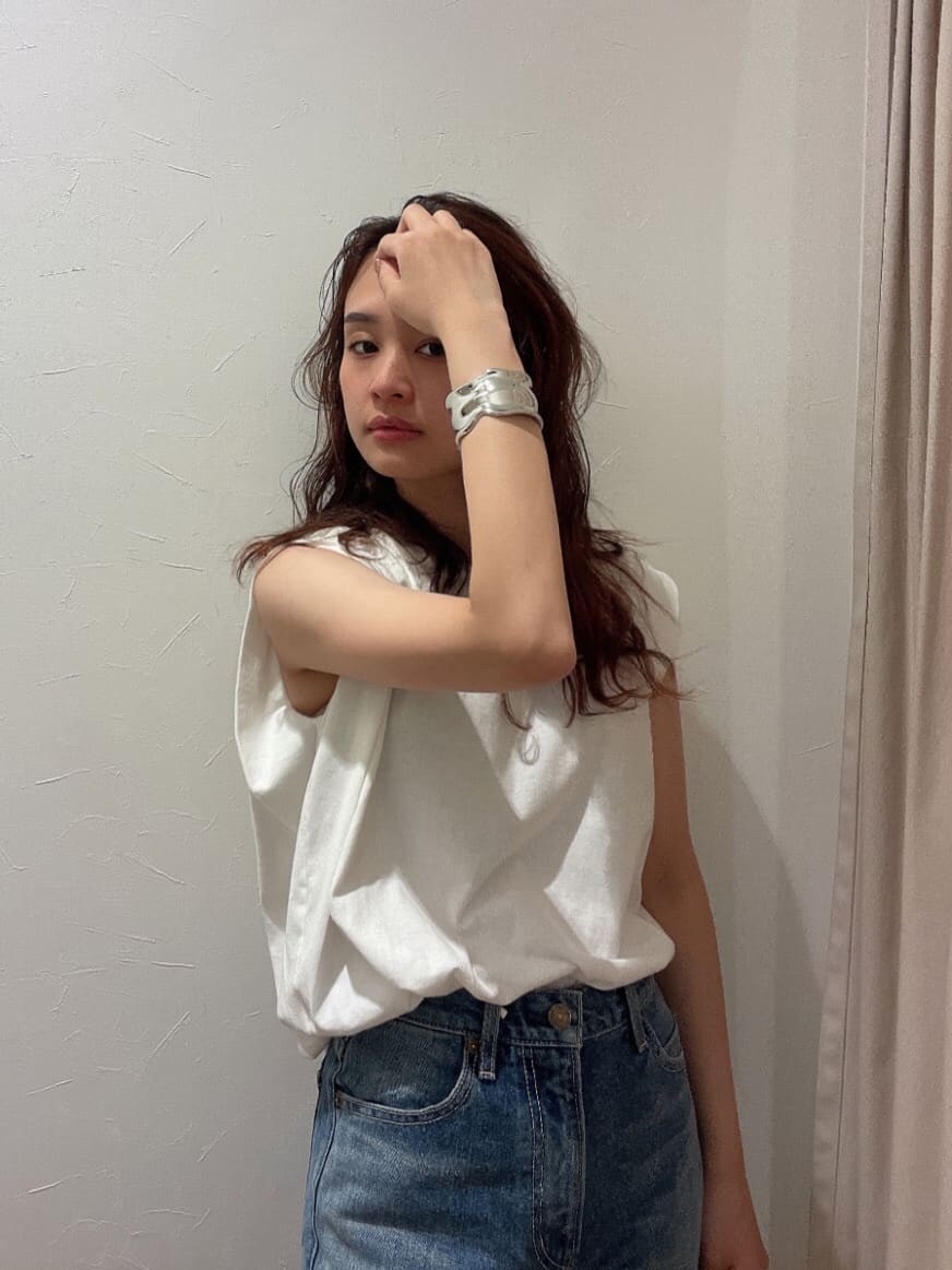 ホワイト系のタンクトップ、ブルー系のデニムパンツ、シルバー系のブレスレットを着用したレディースの春コーディネートの5枚目の写真