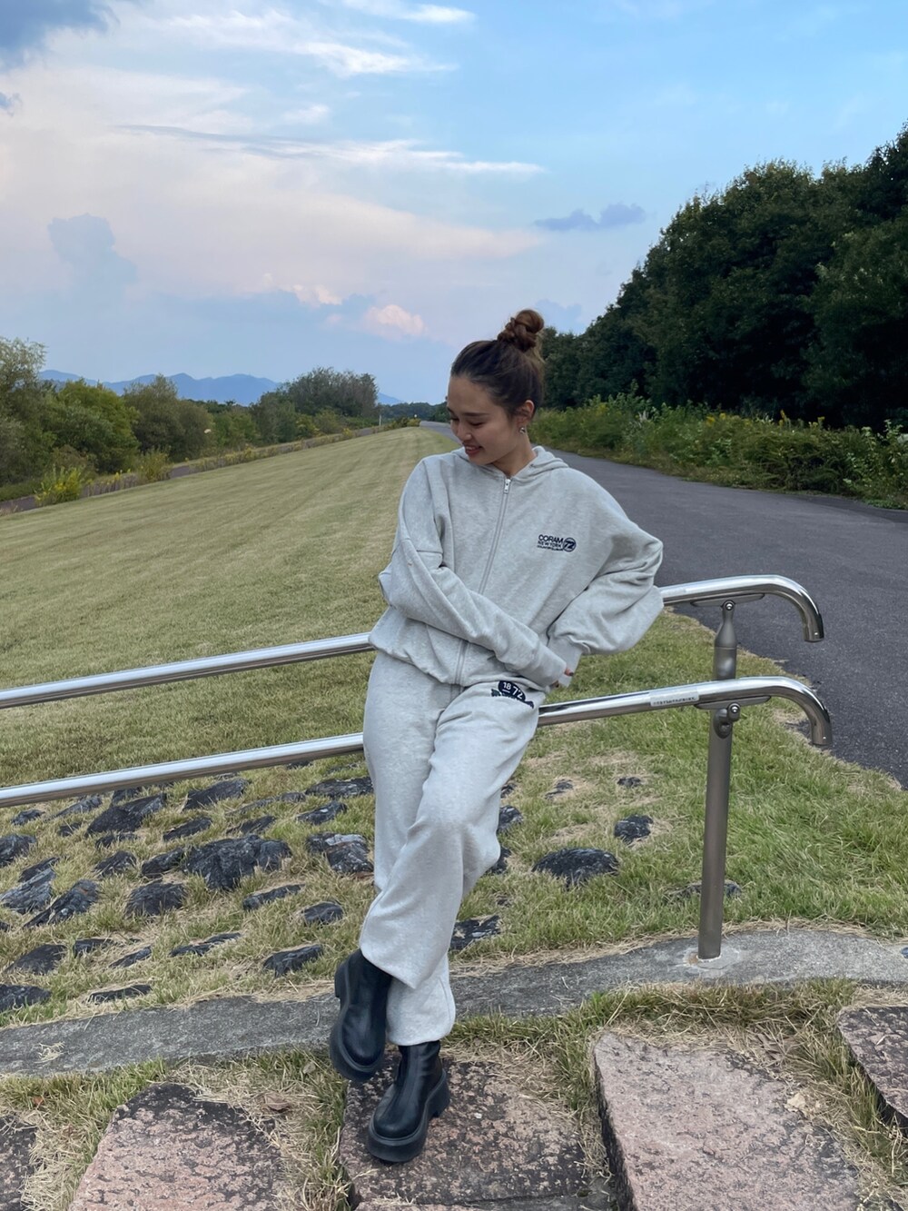 ブラック系のブーツ、グレー系のスウェットパンツ、グレー系のパーカーを着用したレディースの秋コーディネートの6枚目の写真