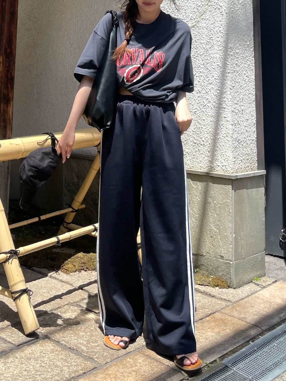 ブルー系のその他パンツ、ブラック系のハンドバッグを着用したレディースの春コーディネートの2枚目の写真