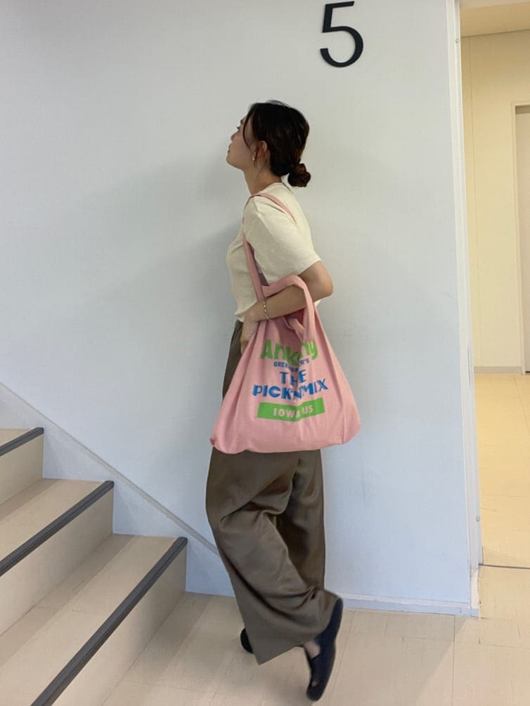 ピンク系のエコバッグ/サブバッグ、ブラウン系のその他パンツ、ホワイト系のTシャツ/カットソーを着用したレディースの夏コーディネートの4枚目の写真
