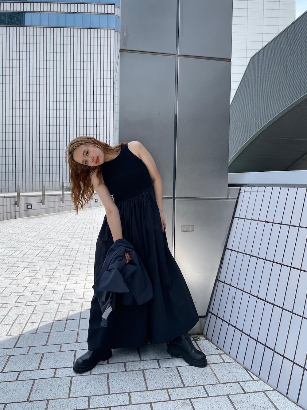 ブラック系のワンピース、グレー系のテーラードジャケットを着用したレディースの春コーディネートの4枚目の写真