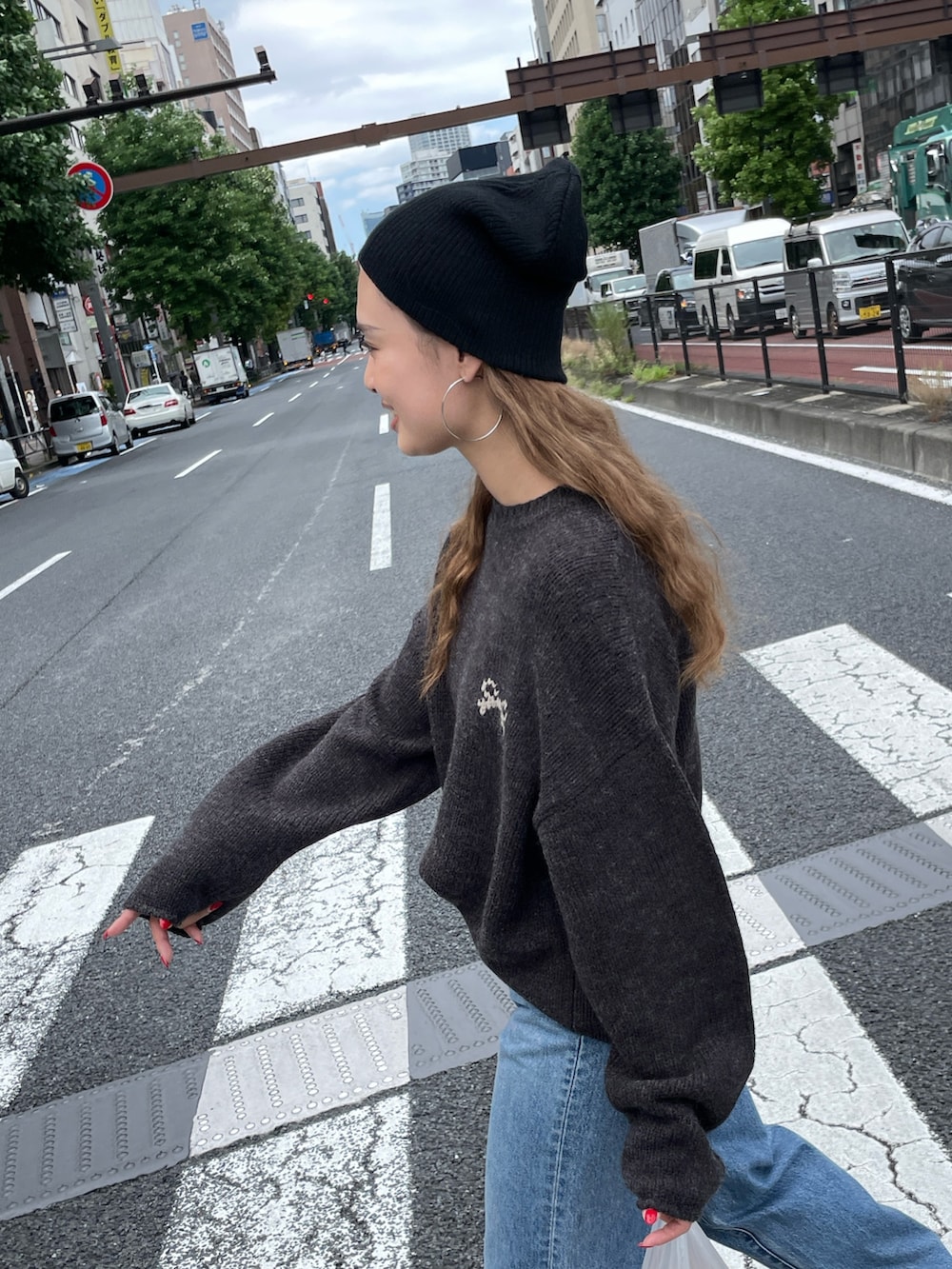 グレー系のニット/セーター、ブルー系のデニムパンツ、ブラック系のニットキャップ/ビーニーを着用したレディースの秋コーディネートの5枚目の写真