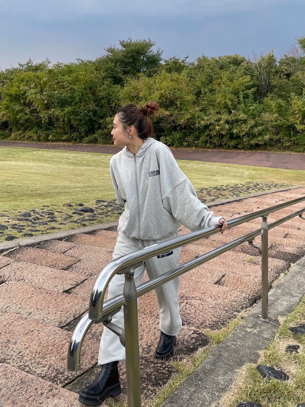 ブラック系のブーツ、グレー系のスウェットパンツ、グレー系のパーカーを着用したレディースの秋コーディネートの2枚目の写真