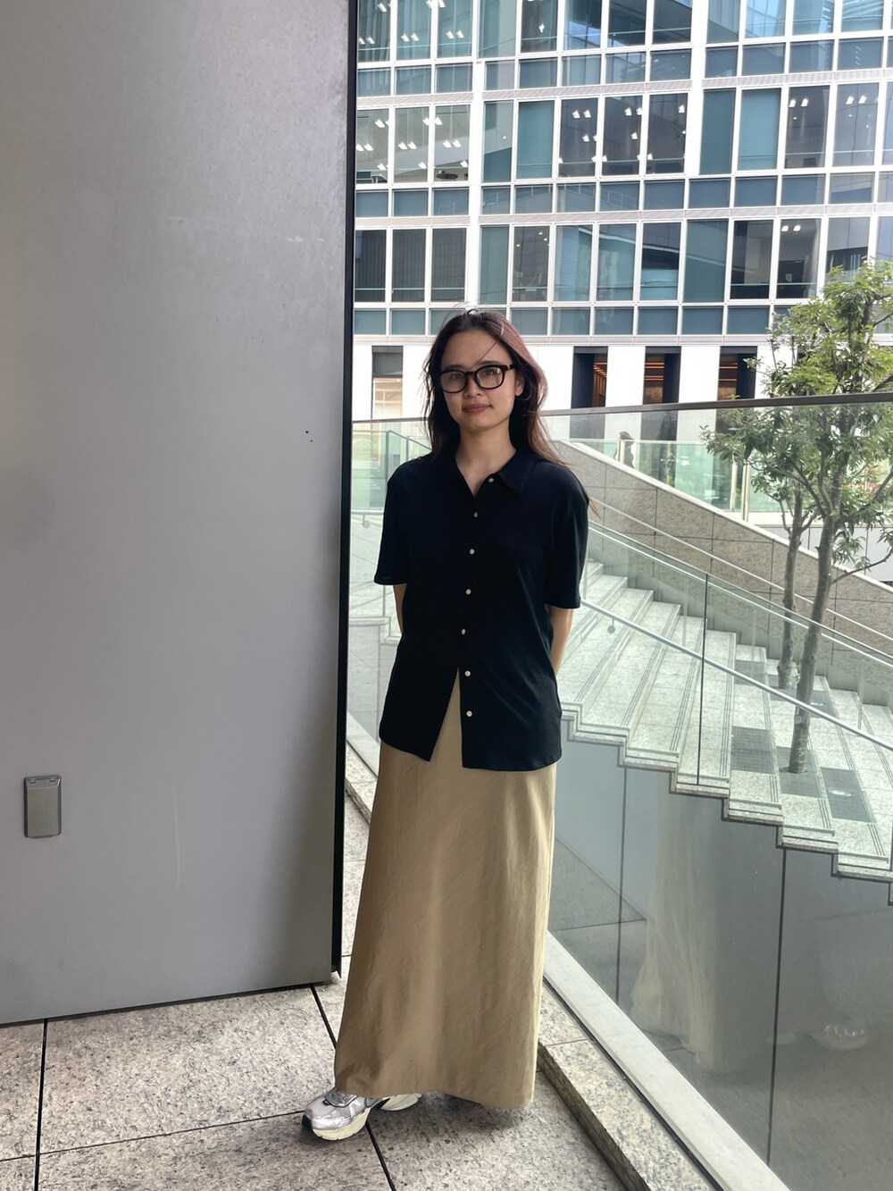 ブラック系のカーディガン/ボレロ、ベージュ系のスカートを着用したレディースの夏コーディネートの3枚目の写真