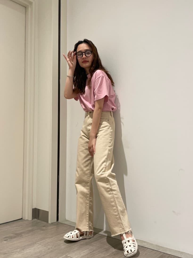 ホワイト系のデニムパンツ、ホワイト系のサンダル、ピンク系のTシャツ/カットソーを着用したレディースの春コーディネートの2枚目の写真