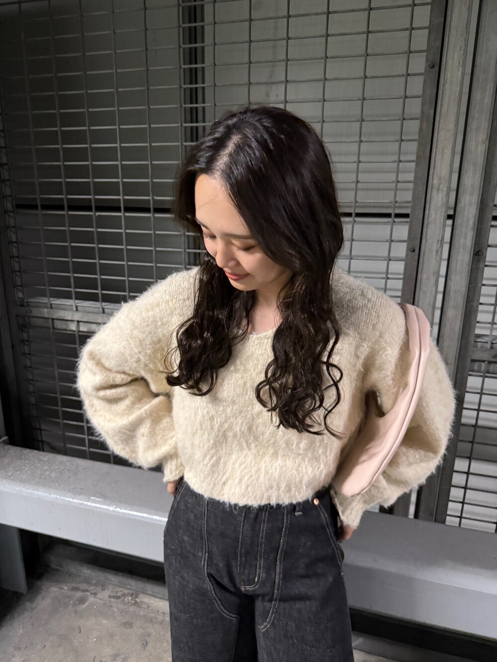 ホワイト系のニット/セーター、ブラック系のデニムパンツを着用したレディースの秋コーディネートの2枚目の写真