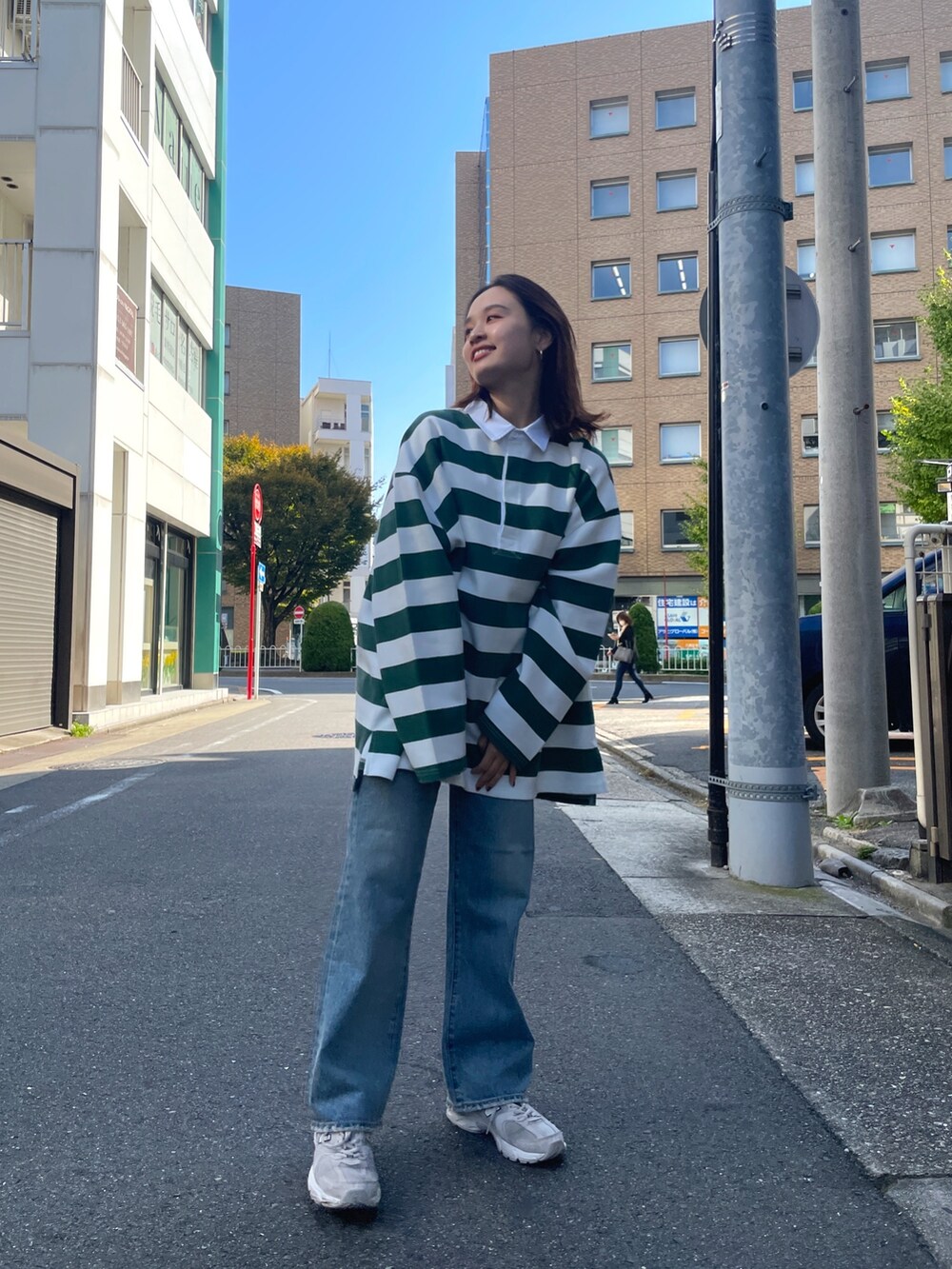 グリーン系のTシャツ/カットソー、ブルー系のデニムパンツを着用したレディースの秋コーディネートの2枚目の写真