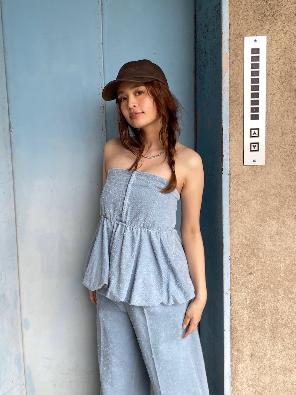 ブルー系のチューブトップ、ブルー系のデニムパンツを着用したレディースの春コーディネートの3枚目の写真