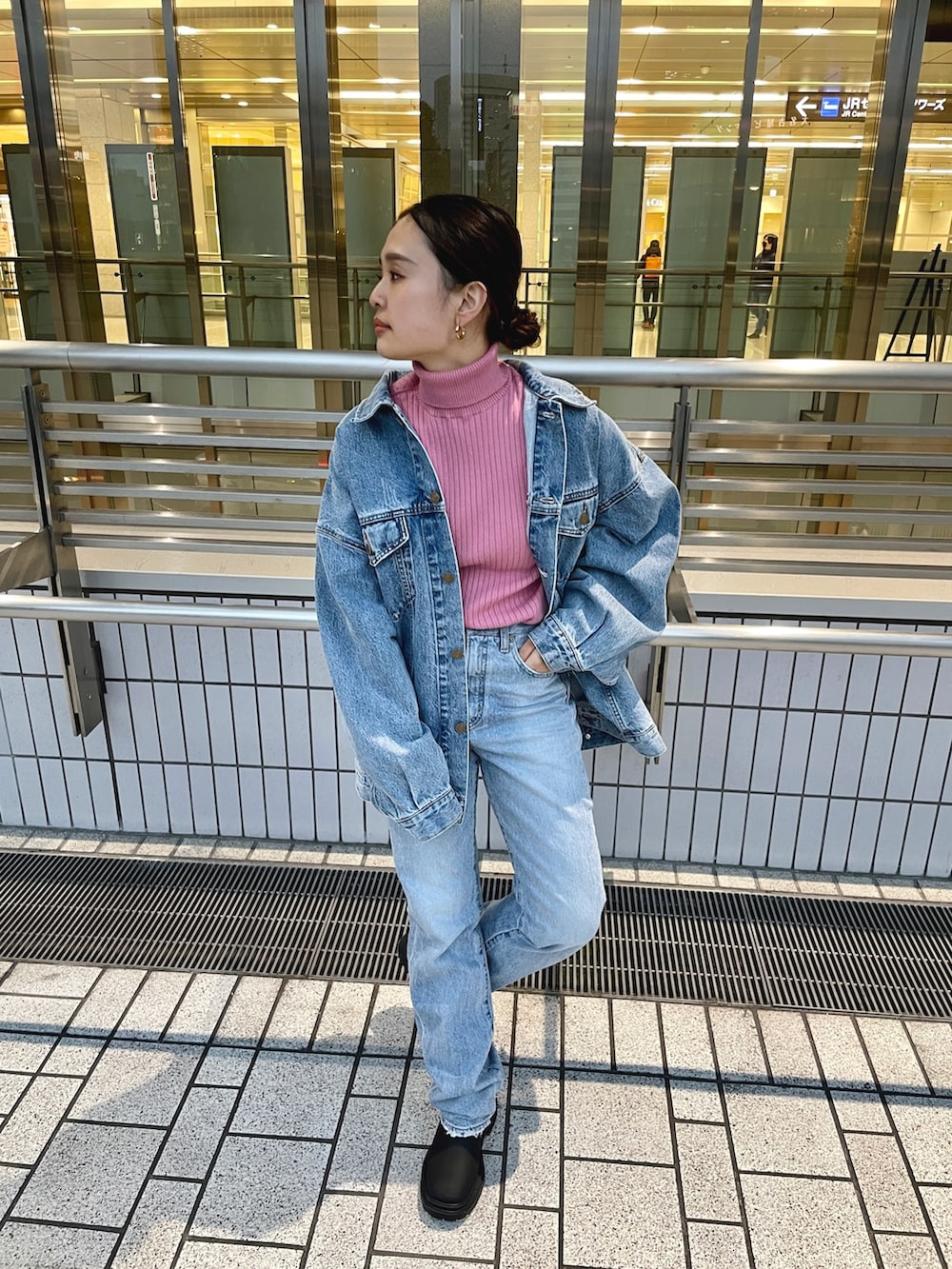 ブルー系のデニムジャケット、ピンク系のニット/セーター、ブルー系のデニムパンツを着用したレディースの冬コーディネートの2枚目の写真