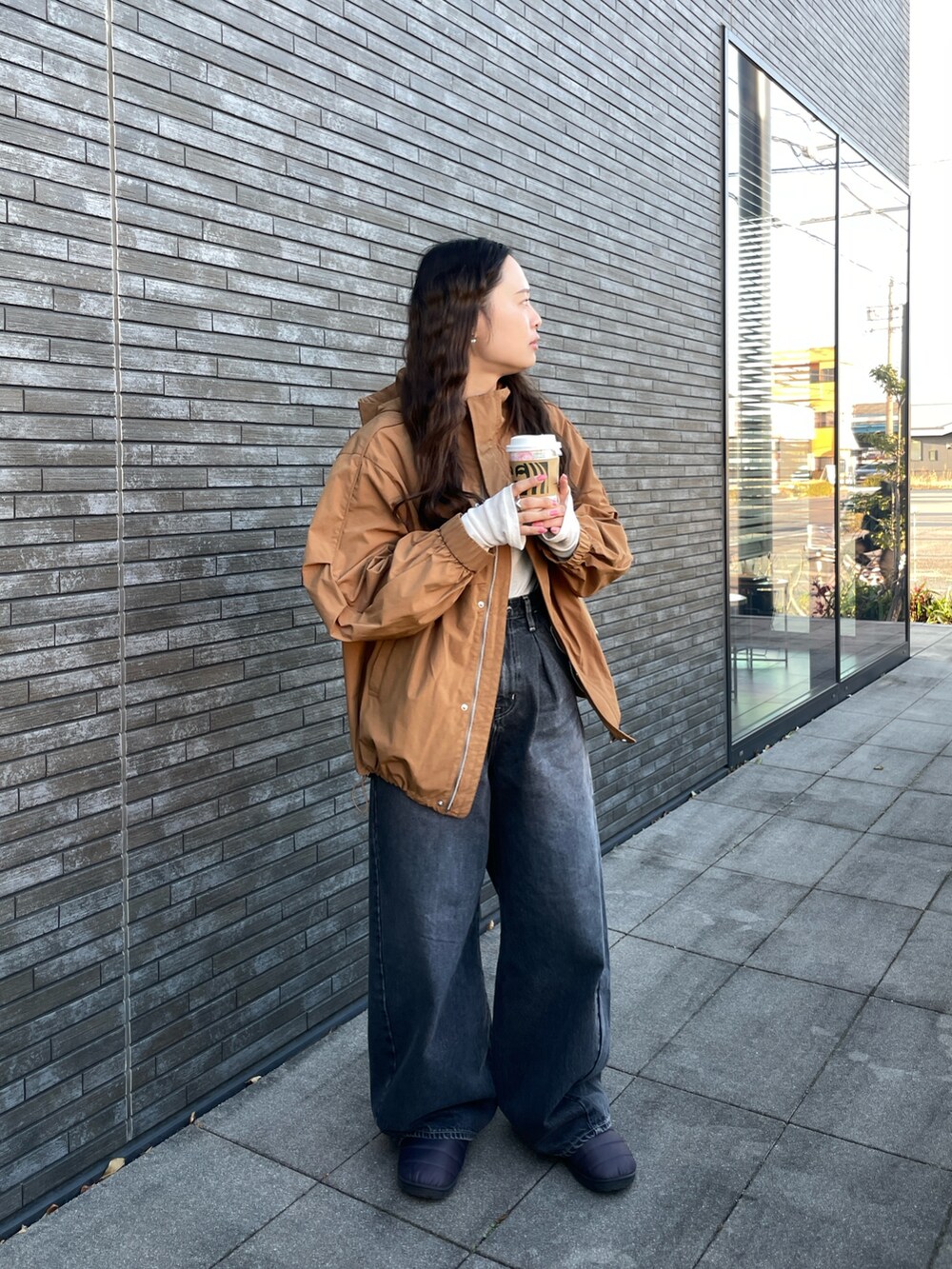 ブラック系のデニムパンツ、ベージュ系のブルゾン、ホワイト系のTシャツ/カットソーを着用したレディースの冬コーディネートの5枚目の写真