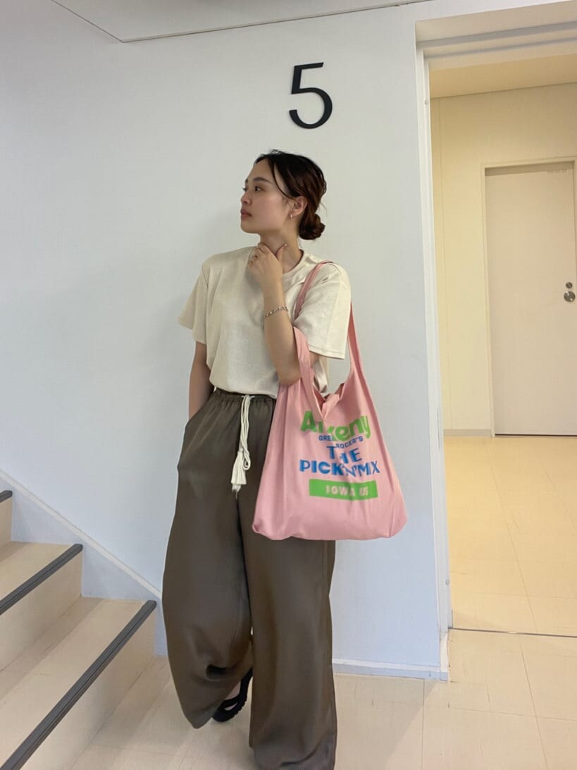 ピンク系のエコバッグ/サブバッグ、ブラウン系のその他パンツ、ホワイト系のTシャツ/カットソーを着用したレディースの夏コーディネートの5枚目の写真