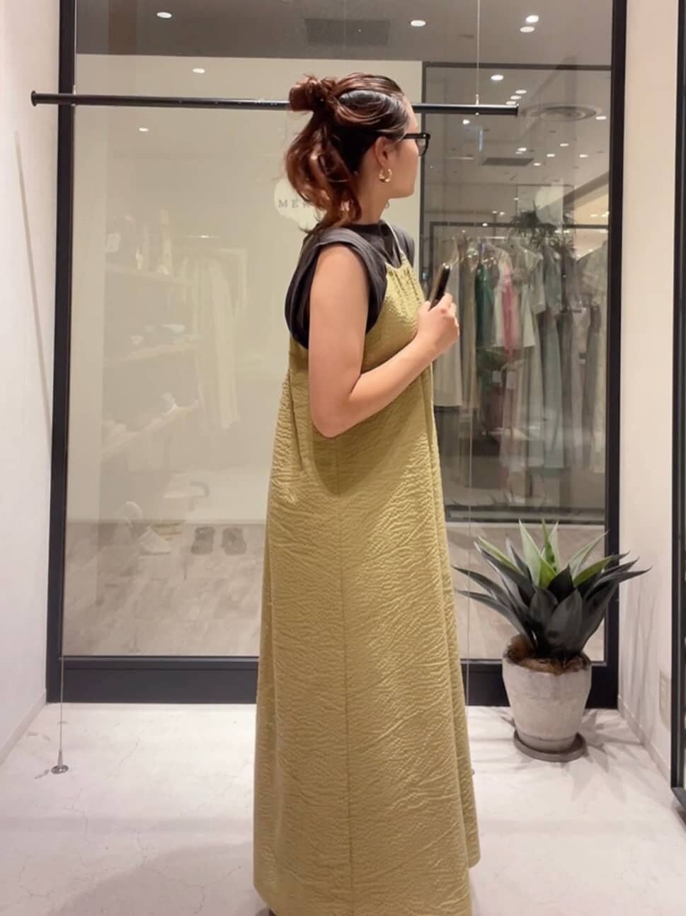 ブラック系のサンダル、グリーン系のワンピース、グレー系のタンクトップを着用したレディースの夏コーディネートの3枚目の写真