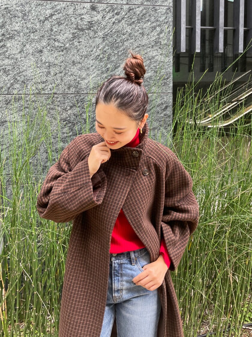 ブルー系のデニムパンツ、ブラウン系のその他アウター、レッド系のニット/セーターを着用したレディースの秋コーディネートの2枚目の写真