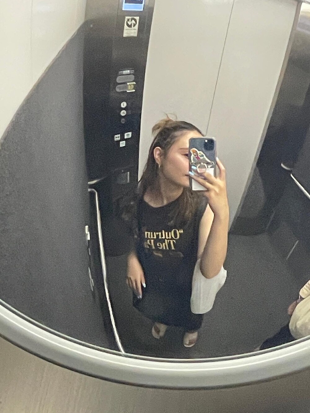 グレー系のタンクトップ、ブラック系のショルダーバッグを着用したレディースの夏コーディネートの2枚目の写真