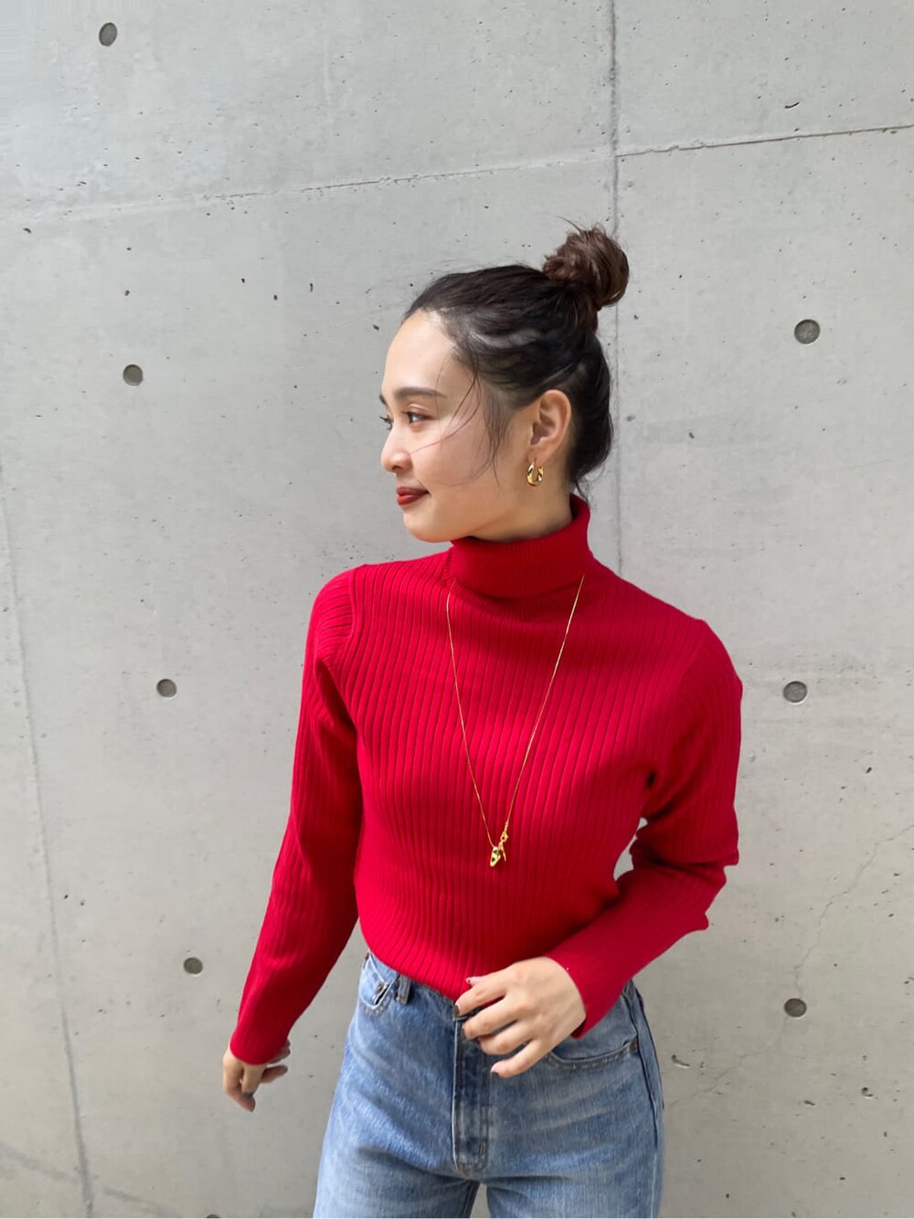 ブルー系のデニムパンツ、ブラウン系のその他アウター、レッド系のニット/セーターを着用したレディースの秋コーディネートの4枚目の写真