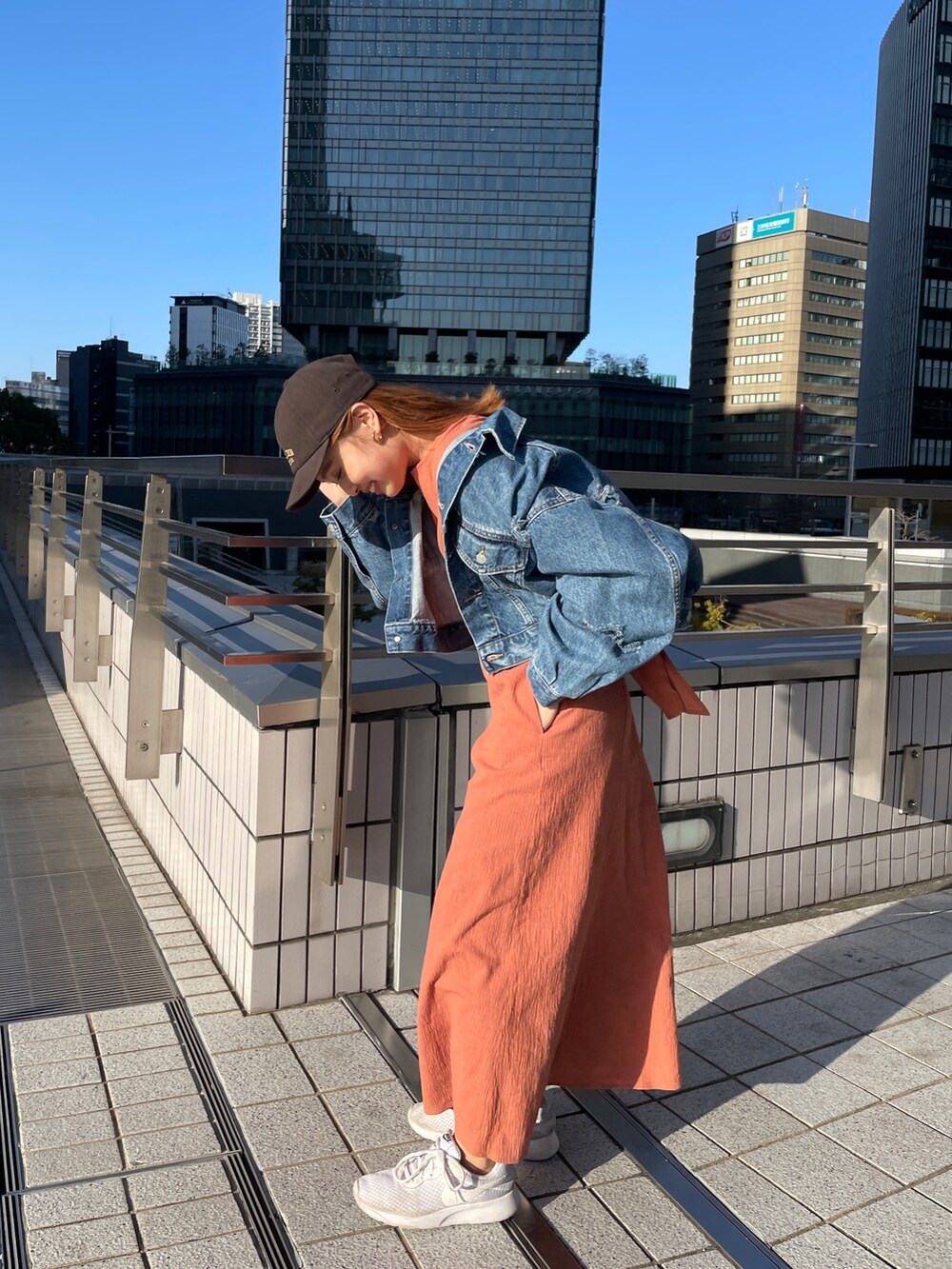 オレンジ系のワンピース、ブルー系のデニムジャケットを着用したレディースの春コーディネートの10枚目の写真