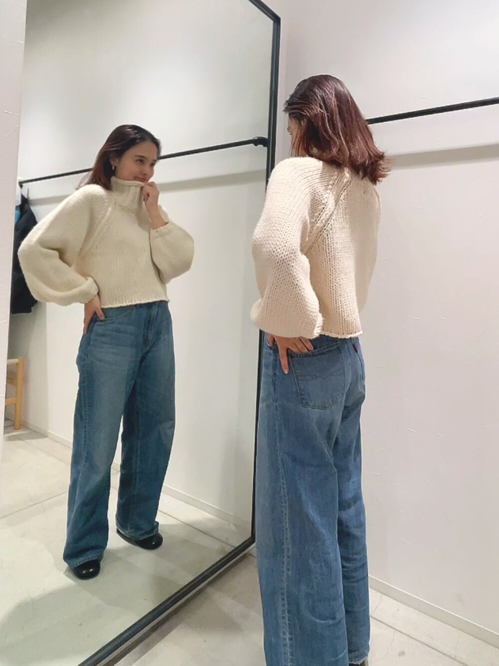 ホワイト系のニット/セーター、ブルー系のデニムパンツを着用したレディースの秋コーディネートの2枚目の写真