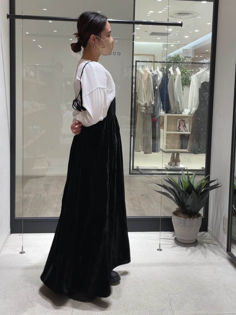 ブラック系のワンピース、ホワイト系のTシャツ/カットソー、ブラック系のブーツを着用したレディースの冬コーディネートの3枚目の写真