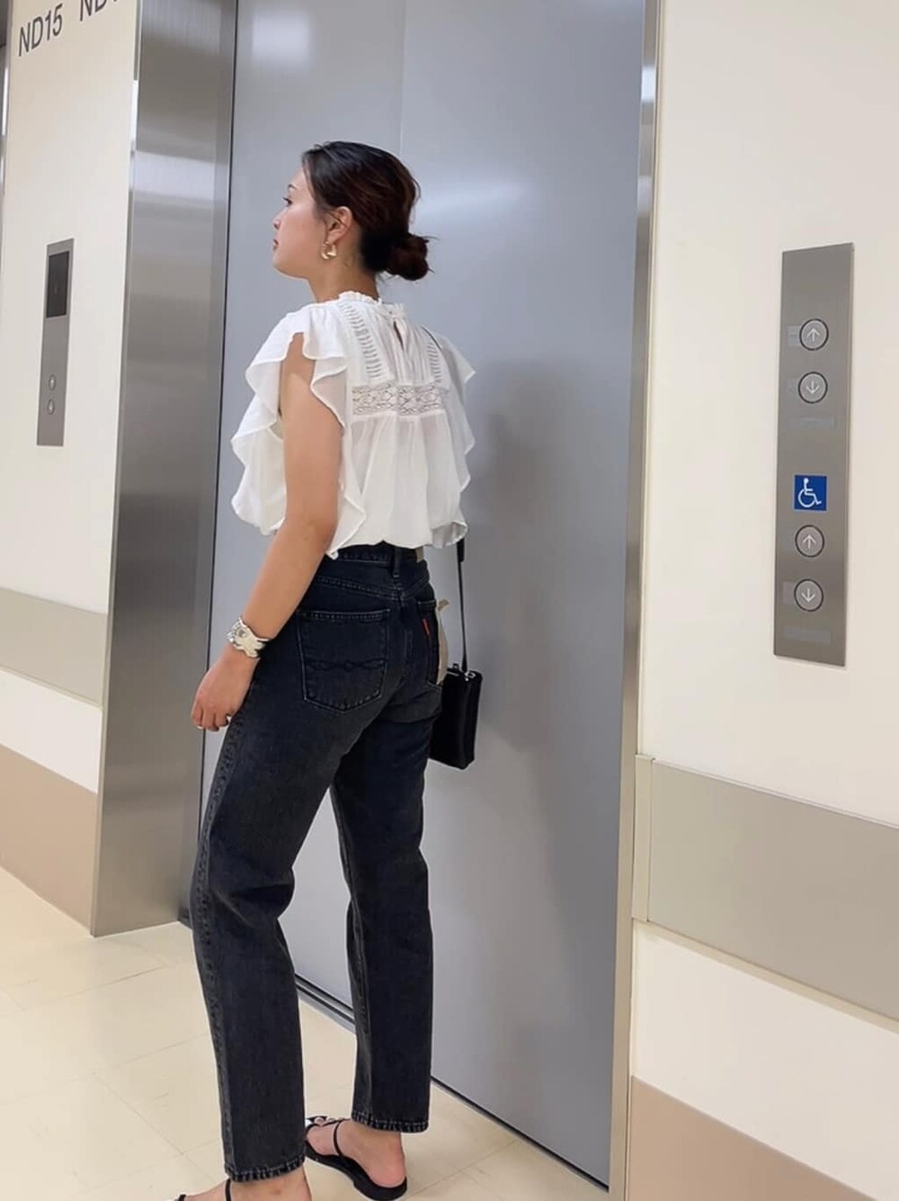 ブラック系のサンダル、ブラック系のショルダーバッグ、ブラック系のデニムパンツを着用したレディースの夏コーディネートの3枚目の写真