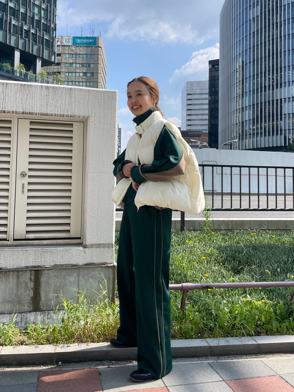 グリーン系のブルゾン、グリーン系のその他パンツ、ホワイト系のダウンベストを着用したレディースの秋コーディネートの3枚目の写真