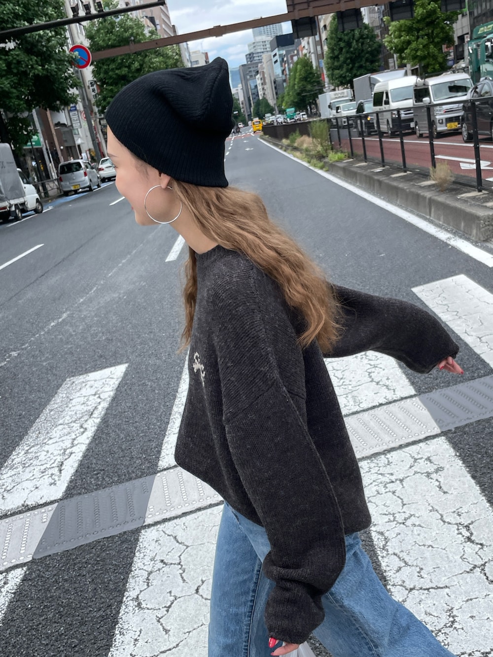 グレー系のニット/セーター、ブルー系のデニムパンツ、ブラック系のニットキャップ/ビーニーを着用したレディースの秋コーディネートの4枚目の写真