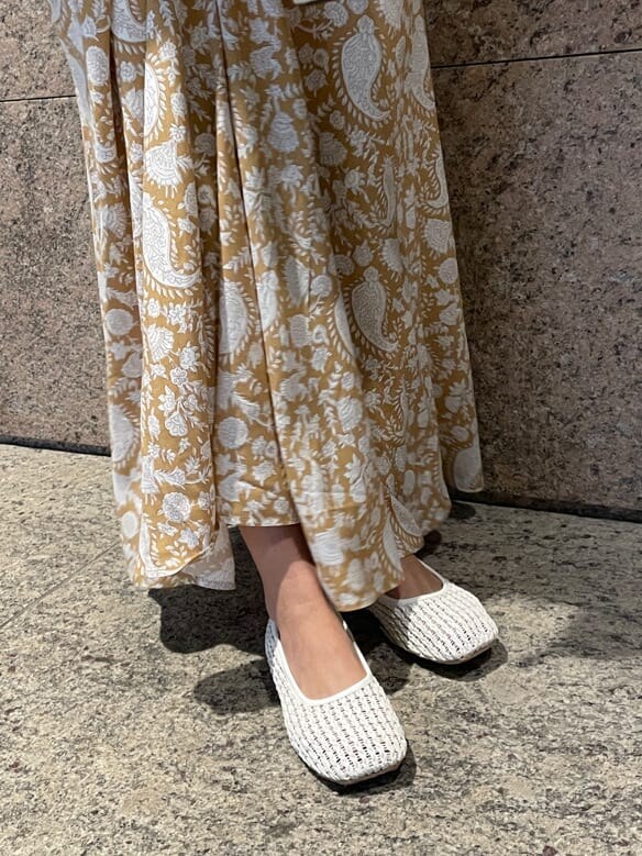 イエロー系のスカート、ホワイト系のパンプス、ホワイト系のカーディガン/ボレロを着用したレディースの冬コーディネートの4枚目の写真