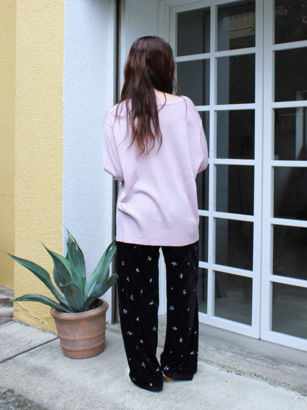 ブラック系のその他パンツ、ピンク系のニット/セーター、ホワイト系のその他シューズを着用したレディースの夏コーディネートの3枚目の写真