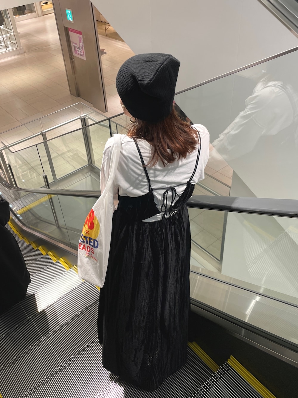 ホワイト系のTシャツ/カットソー、ブラック系のワンピース、ホワイト系のエコバッグ/サブバッグを着用したレディースの冬コーディネートの7枚目の写真