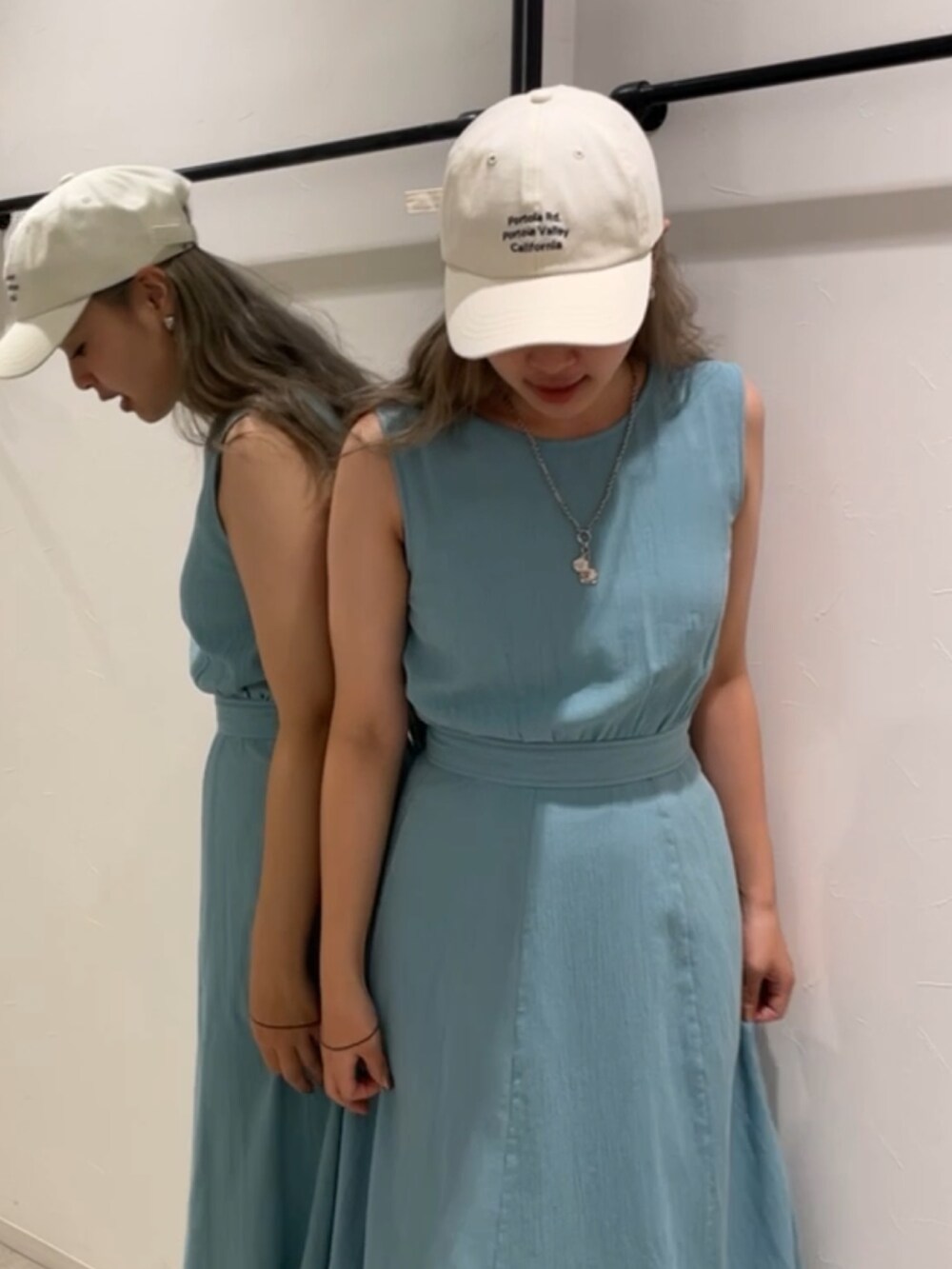 ブルー系のワンピース、ホワイト系のキャップを着用したレディースの夏コーディネートの2枚目の写真