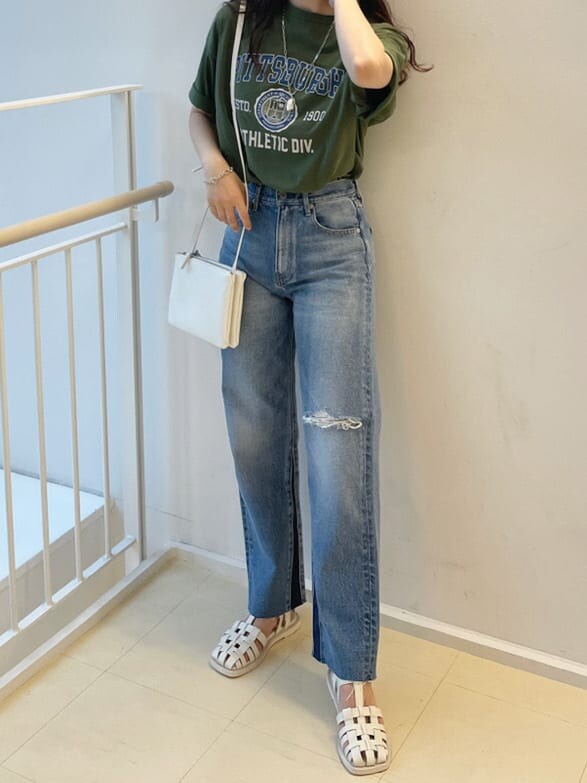 ホワイト系のサンダル、ブルー系のデニムパンツ、ホワイト系のショルダーバッグを着用したレディースの春コーディネートの2枚目の写真