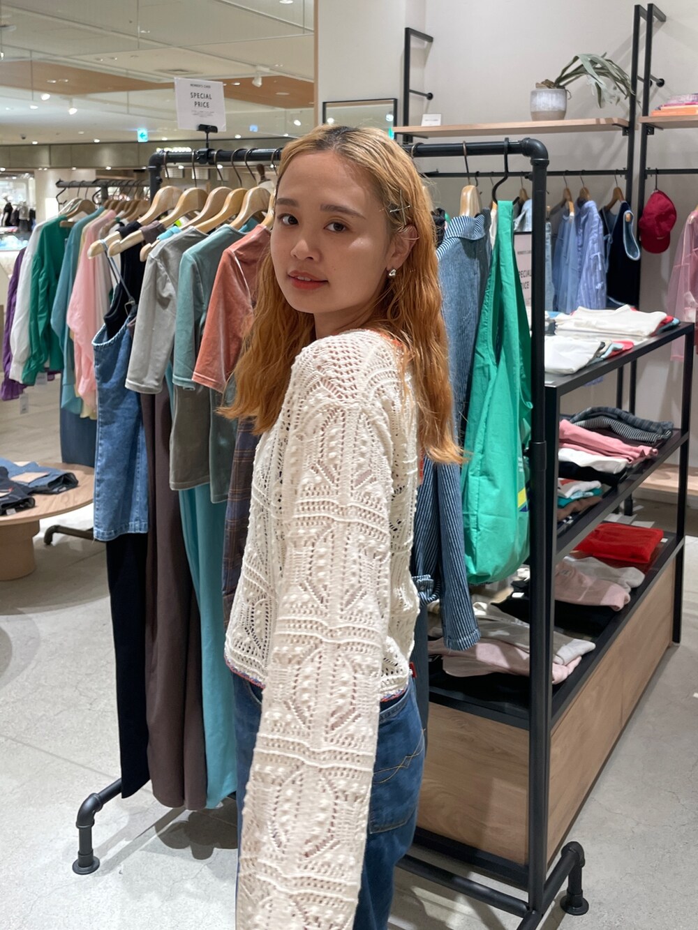 ホワイト系のニット/セーター、ブルー系のデニムパンツを着用したレディースの秋コーディネートの6枚目の写真