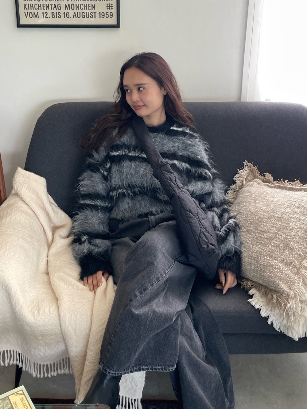 ブラック系のニット/セーター、ブラック系のデニムパンツを着用したレディースの秋コーディネートの3枚目の写真