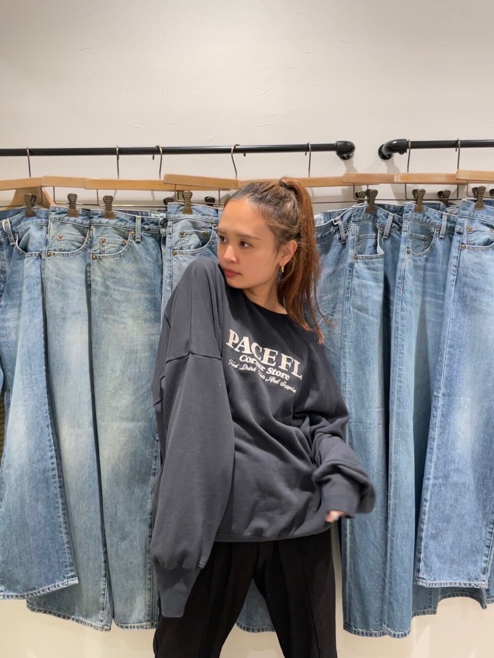 グレー系のスウェット、ブルー系のデニムパンツ、ホワイト系のスニーカーを着用したレディースの夏コーディネートの4枚目の写真