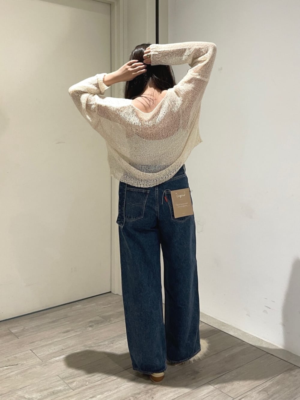 ホワイト系のニット/セーター、ホワイト系のその他シューズ、ブルー系のデニムパンツを着用したレディースの夏コーディネートの3枚目の写真