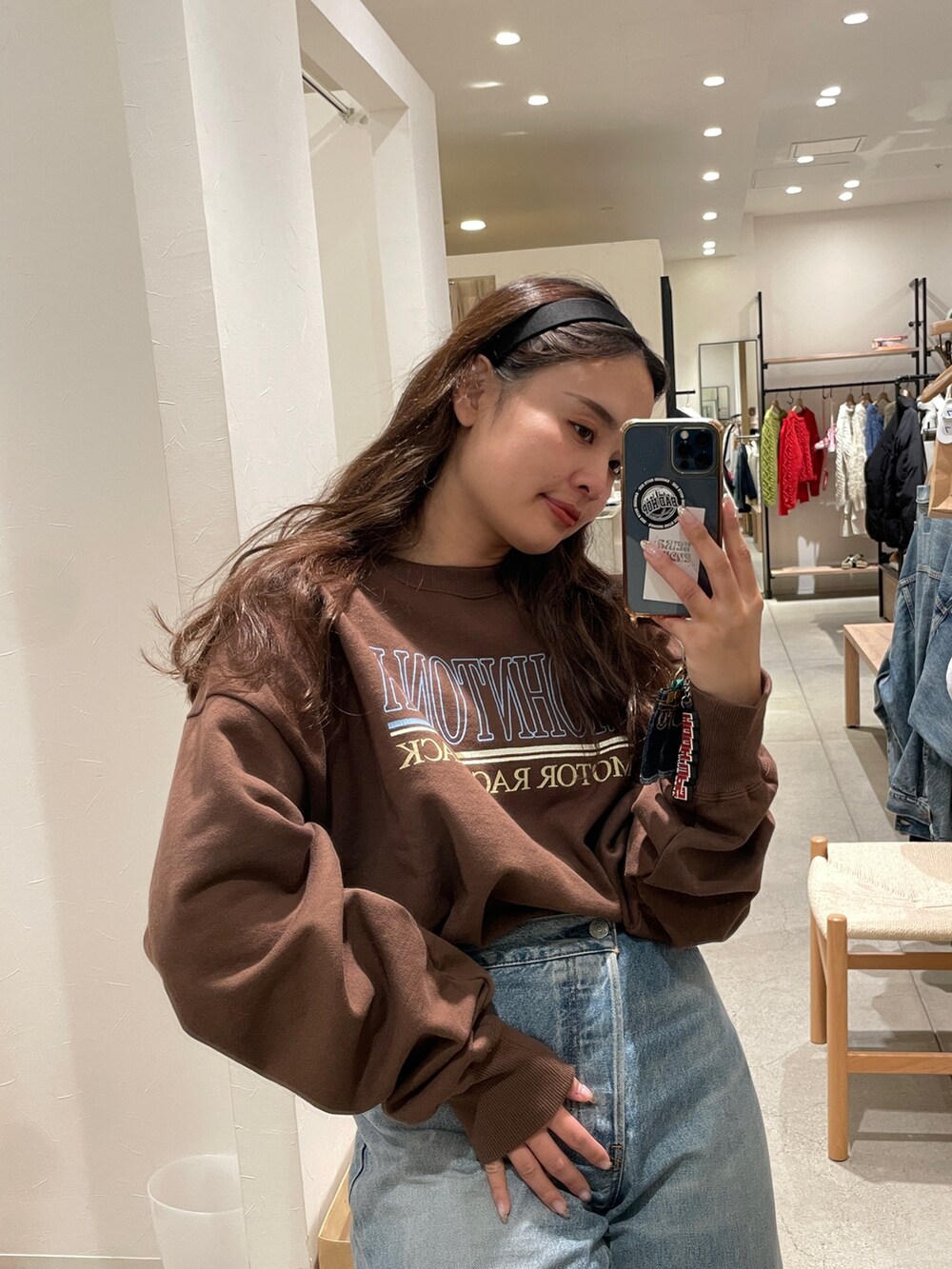 ホワイト系のスウェット、ブルー系のデニムパンツを着用したレディースの冬コーディネートの2枚目の写真